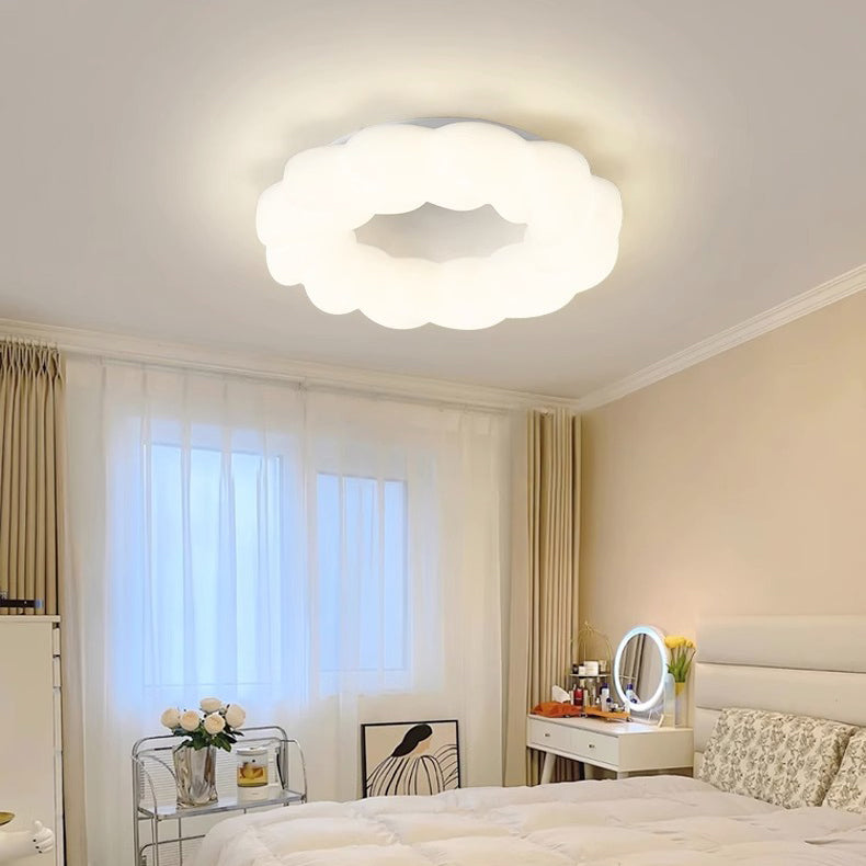 Scena di una camera da letto con una lampada a soffitto a forma di nuvola illuminata, posizionata in alto al centro.
