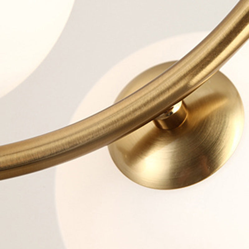 Detailopname van de gouden ijzeren kroonluchterarm en het bevestigingspunt.