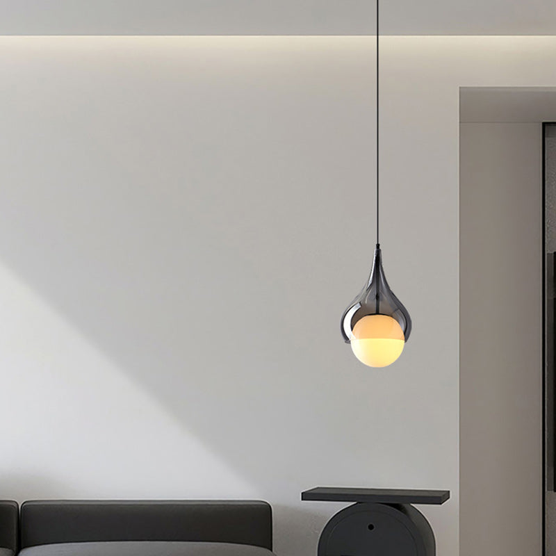 Een enkele hanglamp is geïnstalleerd boven een moderne zithoek.