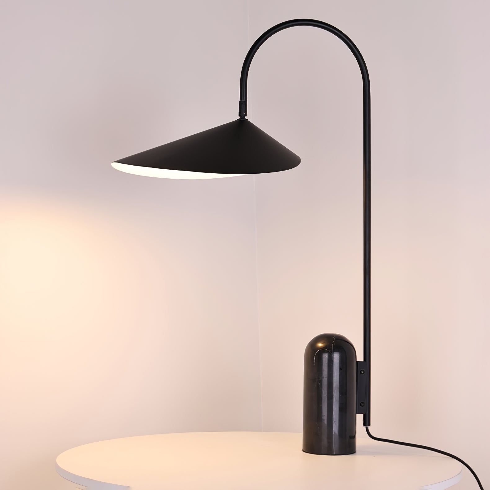 Schwarze Lampe auf kleinem runden Tisch