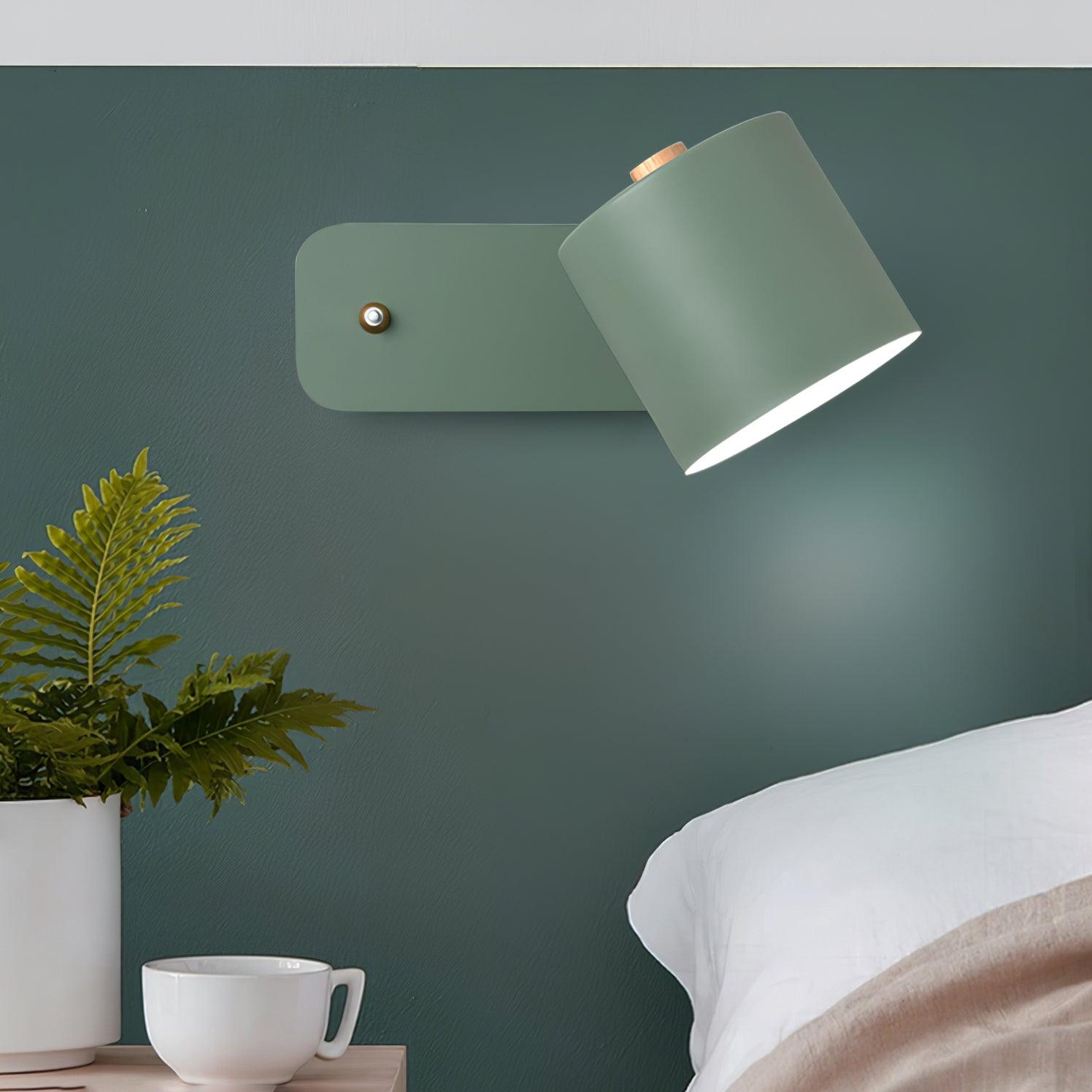 Draaibare cilindervormige wandlamp boven het nachtkastje