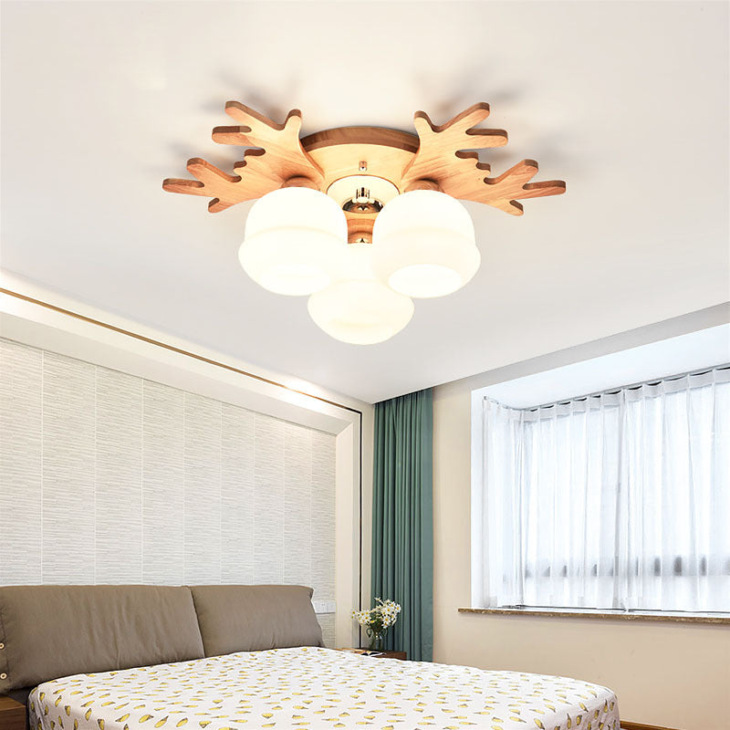 In einem Schlafzimmer wurde eine Deckenleuchte aus Holz und Glas in Form eines Geweihs installiert.