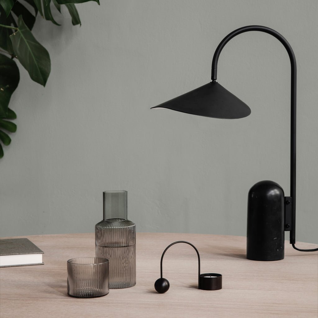 Schwarze Lampe auf dem Tisch mit Glaswaren