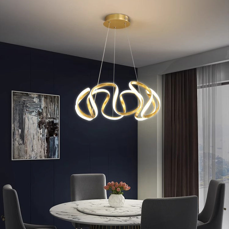 Lampadario a LED dorato installato sopra un tavolo da pranzo.