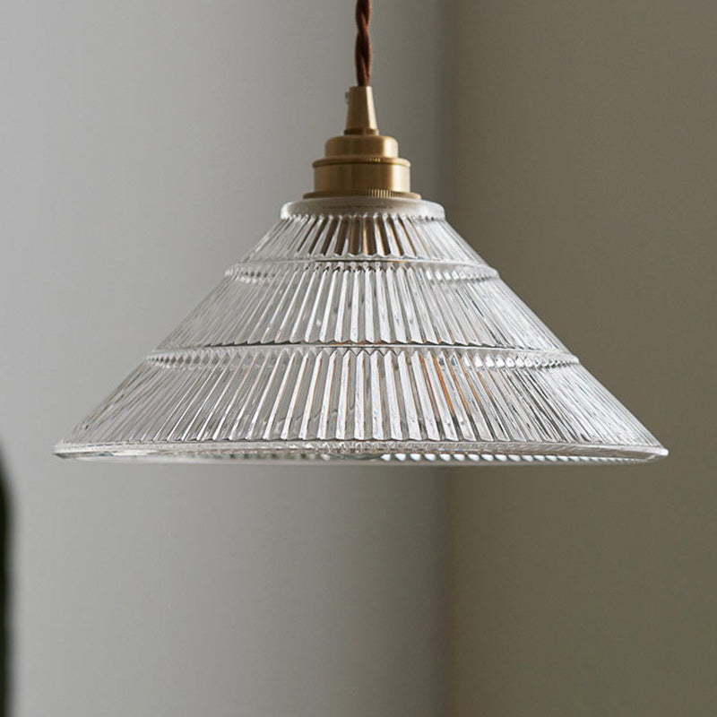 Nahaufnahme des transparenten, gerippten Glasschirms und der Kupferbeschläge der Pendelleuchte