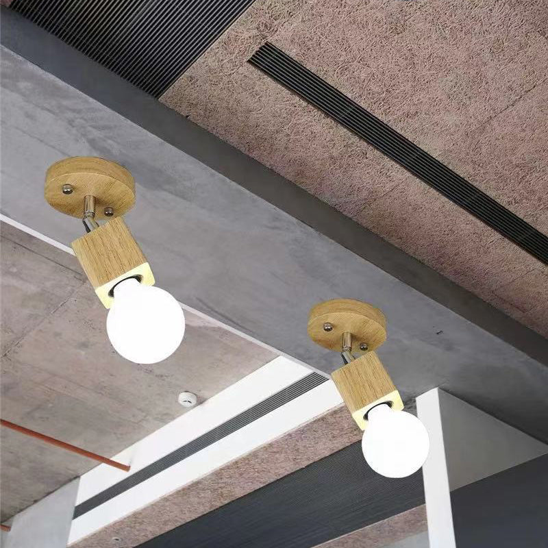 Twee enkele, halfverzonken plafondlampen van hout, geïnstalleerd in een binnenplafond.