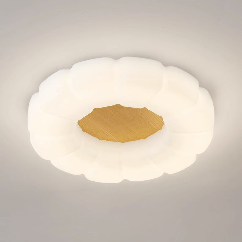 Primo piano di una lampada a soffitto a forma di nuvola illuminata con dettaglio centrale dorato.