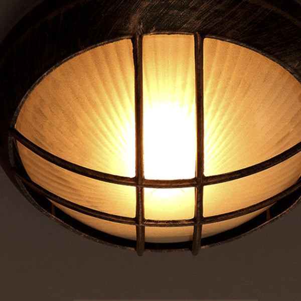 Détail de la face inférieure d'un abat-jour encastré rond en verre et cage en fer illuminé