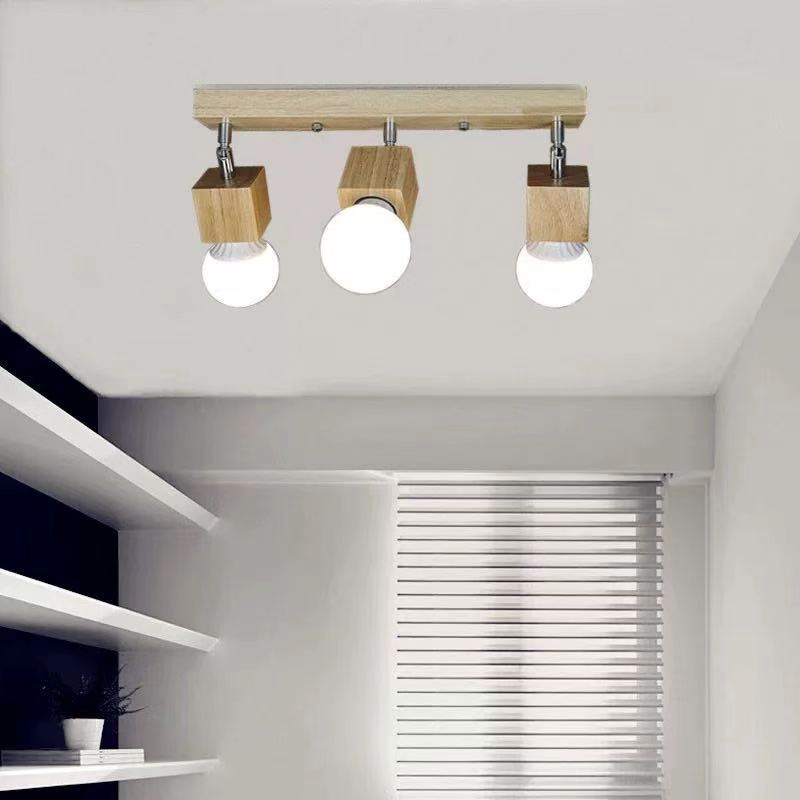 Een lineaire plafondlamp met drie lampen van hout, halfverzonken, is in een kamer geïnstalleerd.