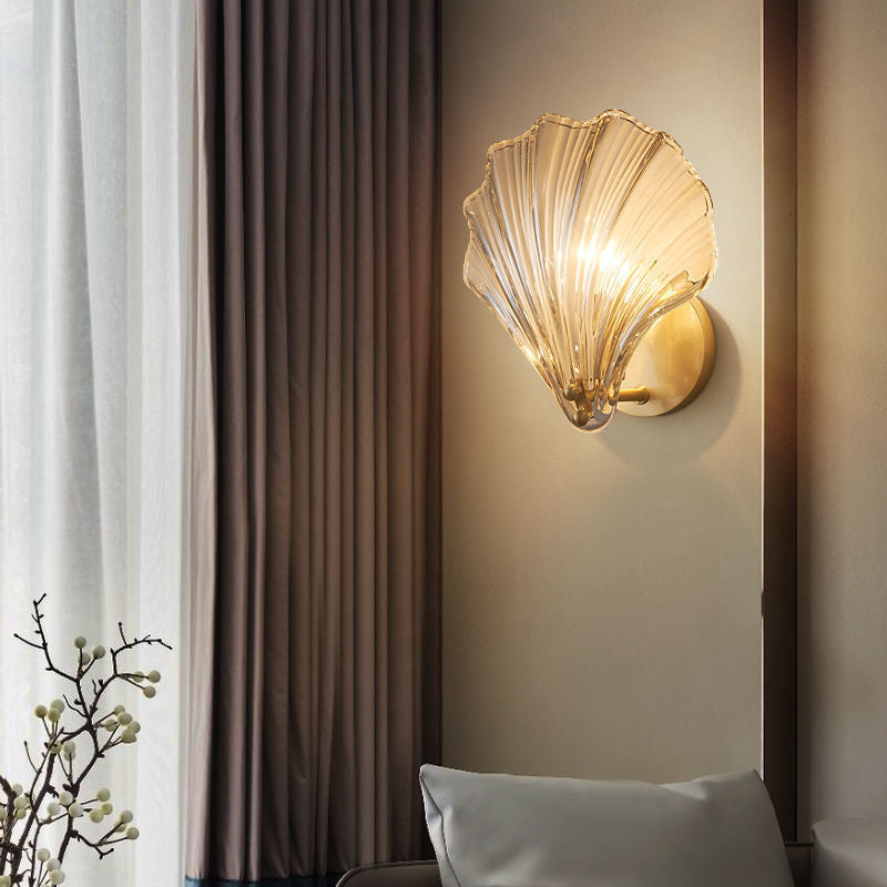Aplique de pared con forma de concha de cristal oceánico cerca de las cortinas en una zona de estar.
