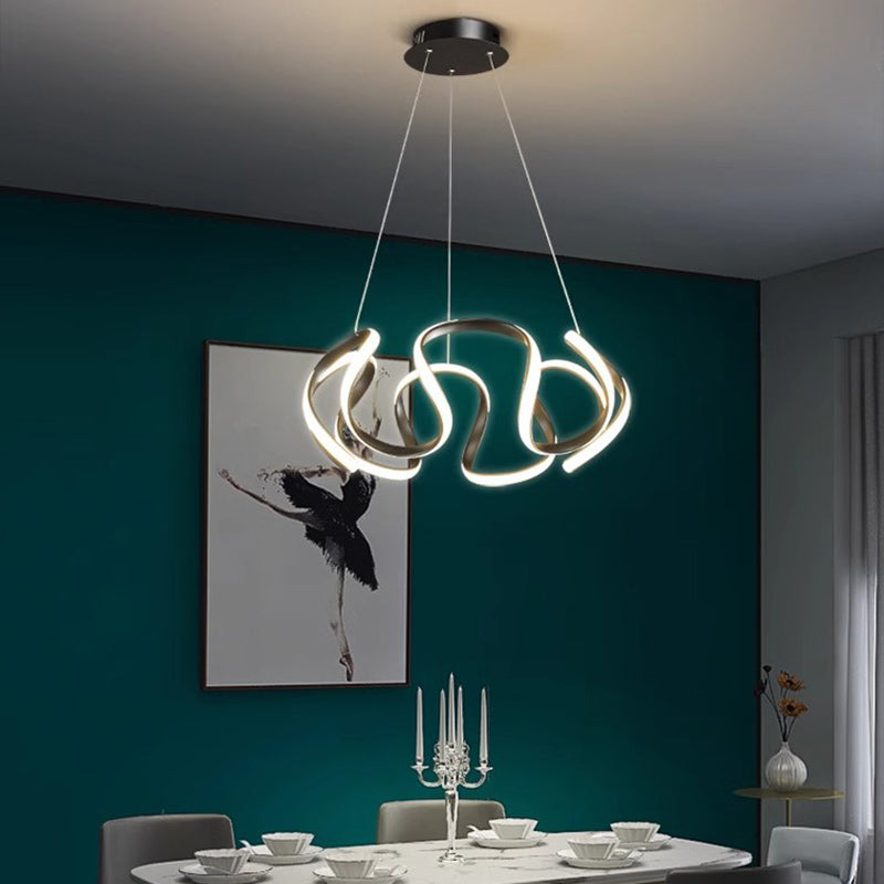 Lampadario nero installato sopra un tavolo da pranzo in una stanza con pareti color verde acqua.