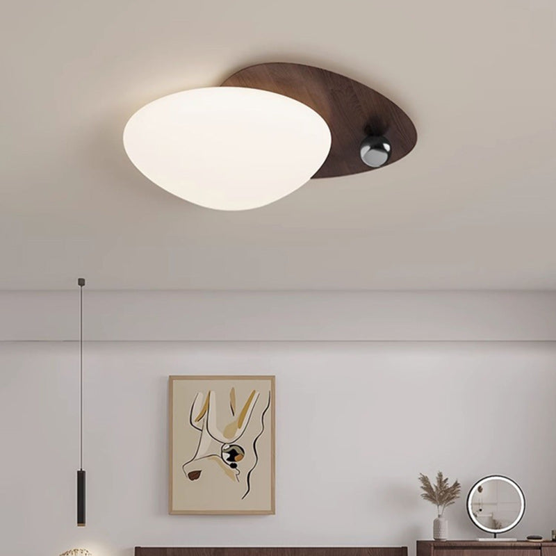 Lampadario a sospensione a forma di sfera effetto ciottoli in una calda ambientazione.