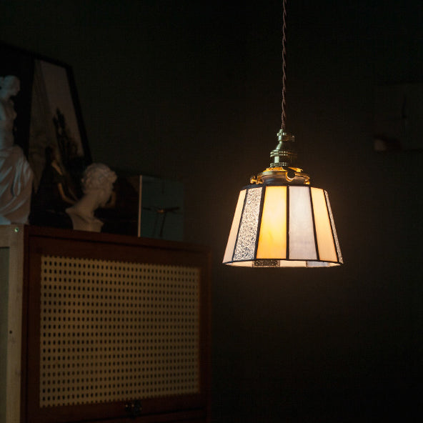 Hanglamp van gestreept Japans glas, verlicht in een donkere woonkamer.
