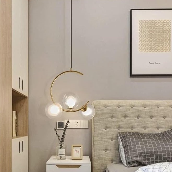Een bolvormige kroonluchter met drie lampen, afgebeeld naast een bed.