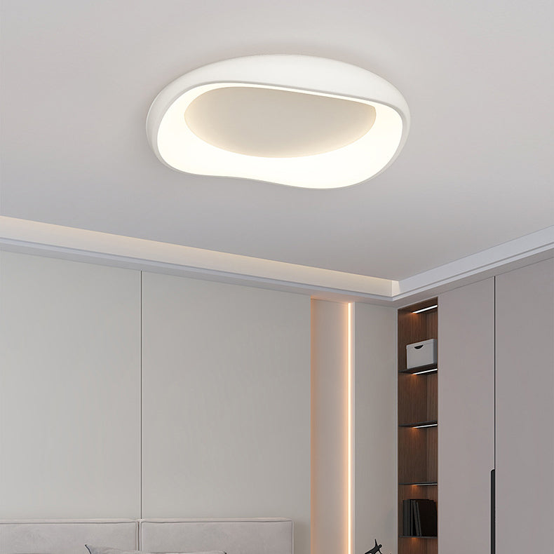 Plafoniera a LED bianca, rotonda e irregolare, in una scena di camera da letto.