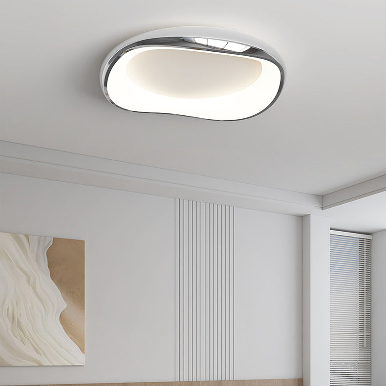 Plafoniera rotonda irregolare cromata o con bordi scuri, installata in una camera da letto.