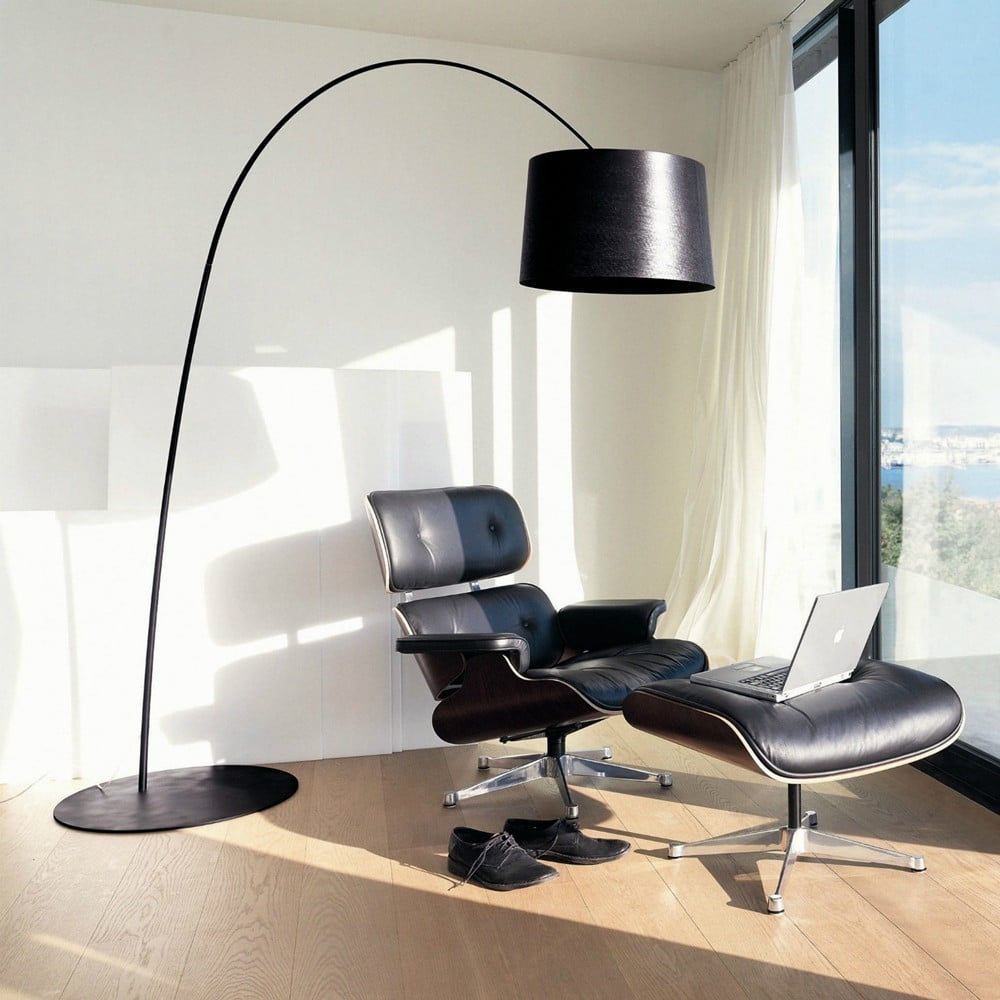 Lampadaire mince et atmosphérique à côté d'un fauteuil dans un salon lumineux