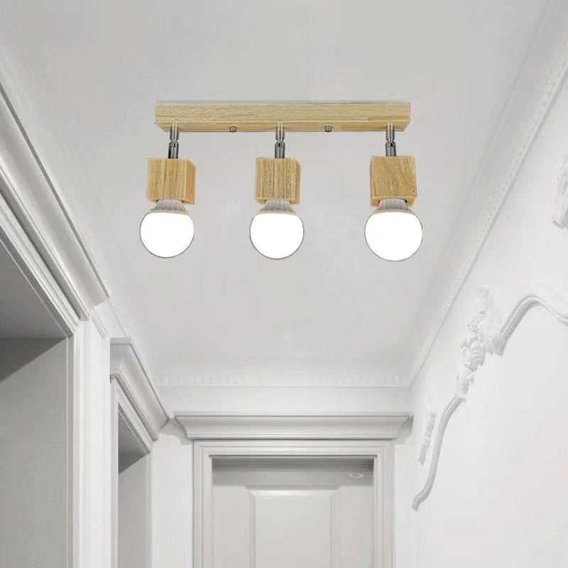 Plafondarmatuur met drie lampen van hout, geïnstalleerd in een gangplafond.