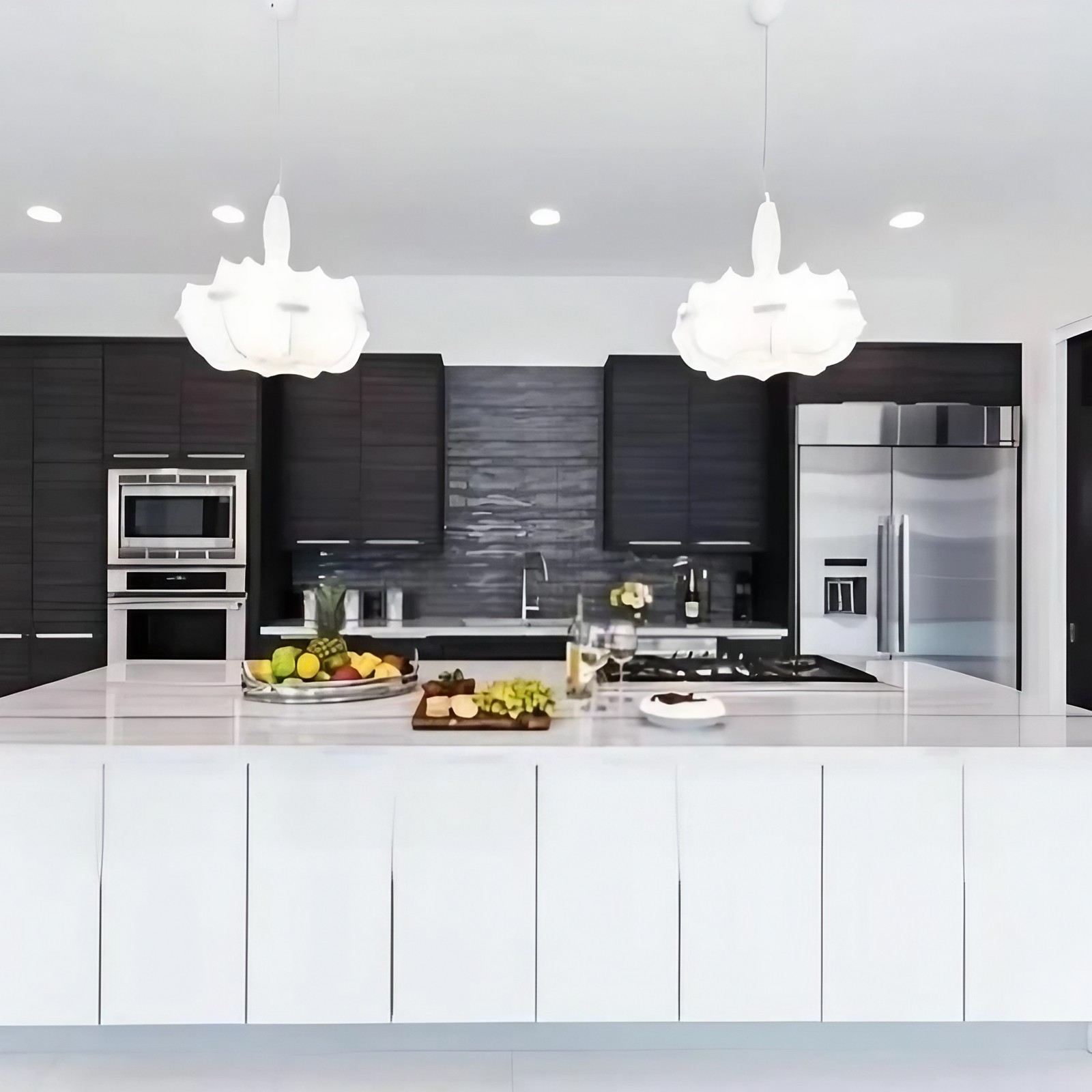 Due lampadari a forma di bozzolo sopra una moderna isola cucina.