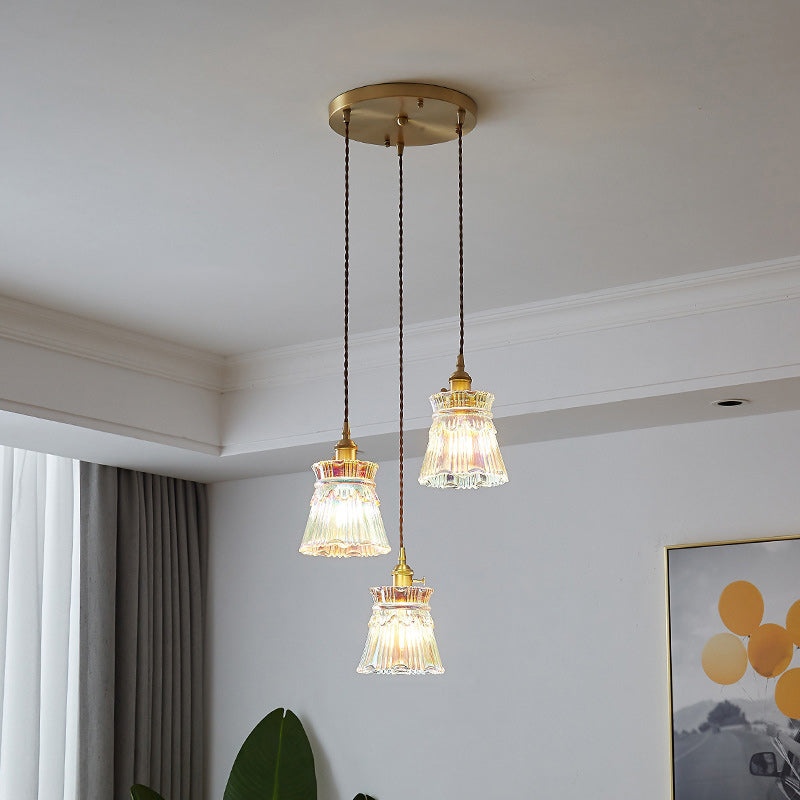 Hanglamp met drie lampen en ronde voet in de woonkamer.