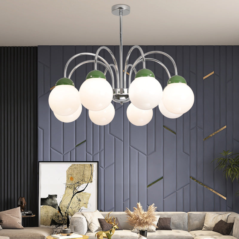Groene bolvormige kroonluchter met meerdere lampen in een woonkamer met een donkere accentmuur.
