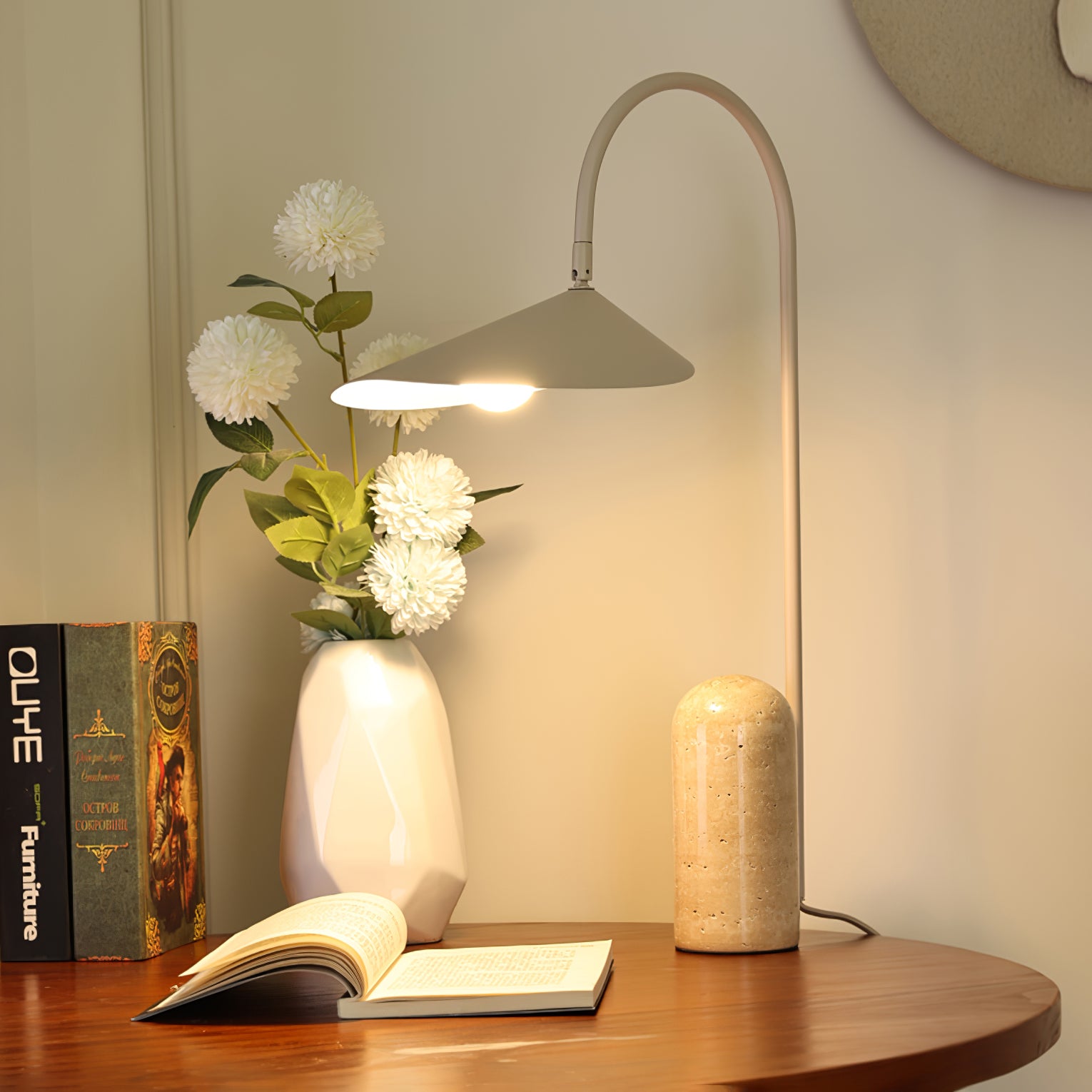 Eine Kaschmirlampe steht auf einem Schreibtisch mit Büchern und einer Vase.