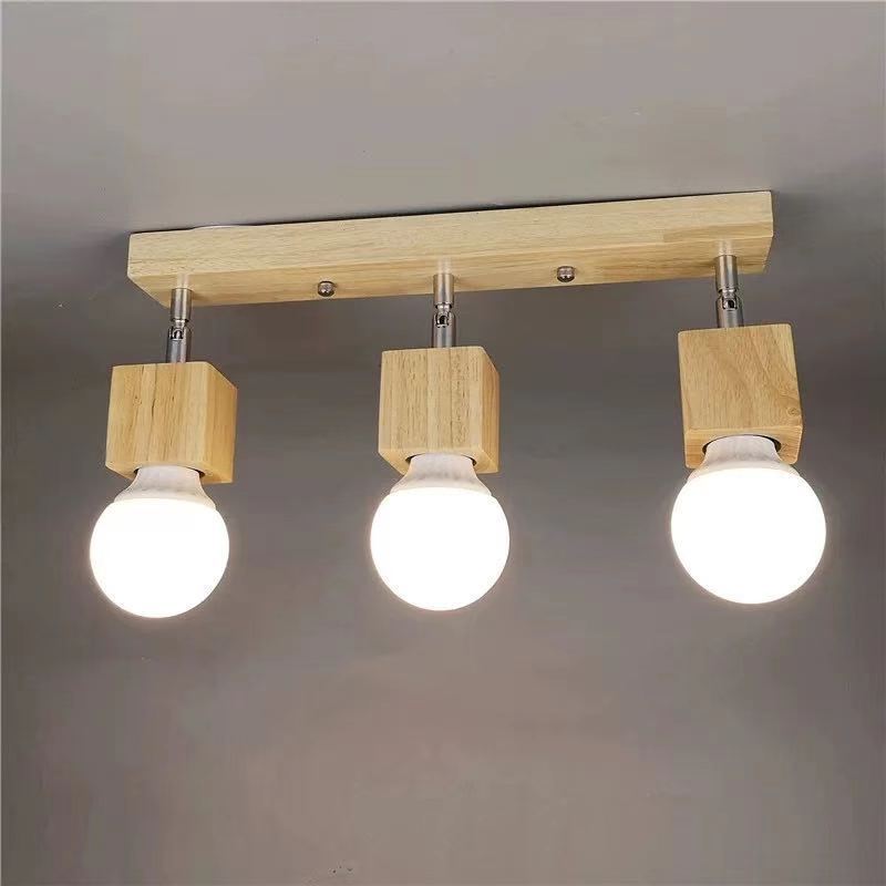 Plafondarmatuur met drie lampen, halfverzonken in hout, in een donkere kamer.