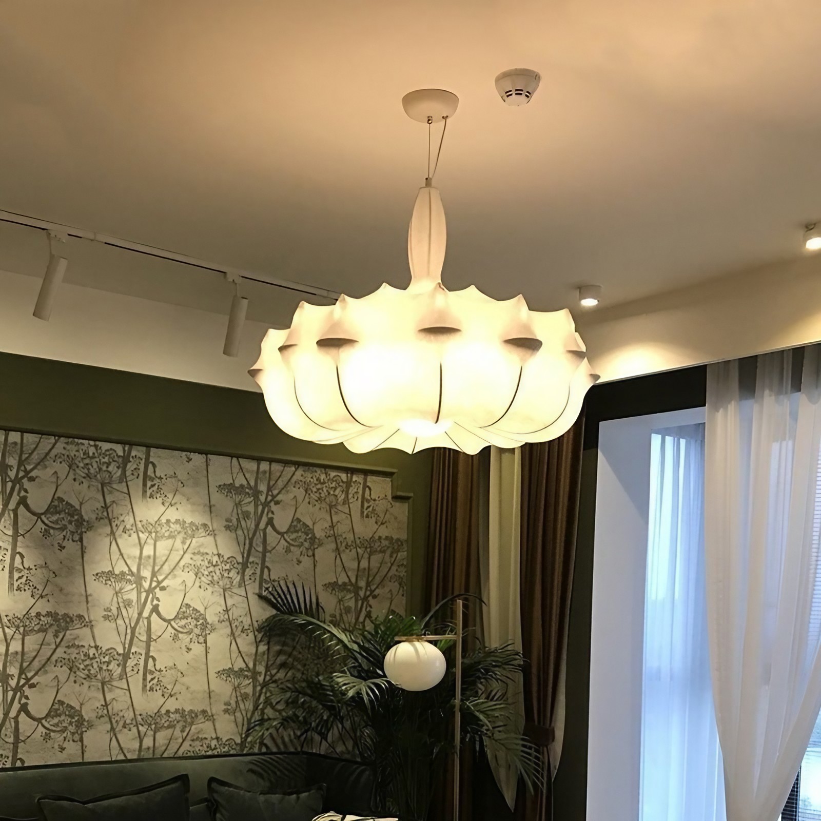 Lampadario a bozzolo con luce calda per ambienti luminosi.