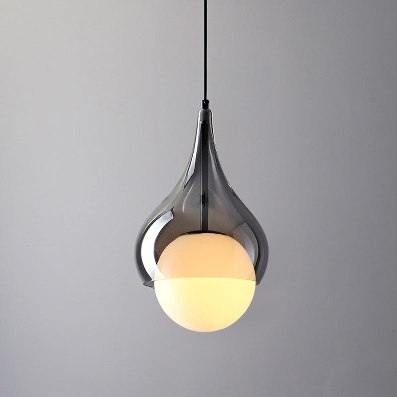Verlichte close-up van een hanglampkap en bolvormige diffuser van rookglas.