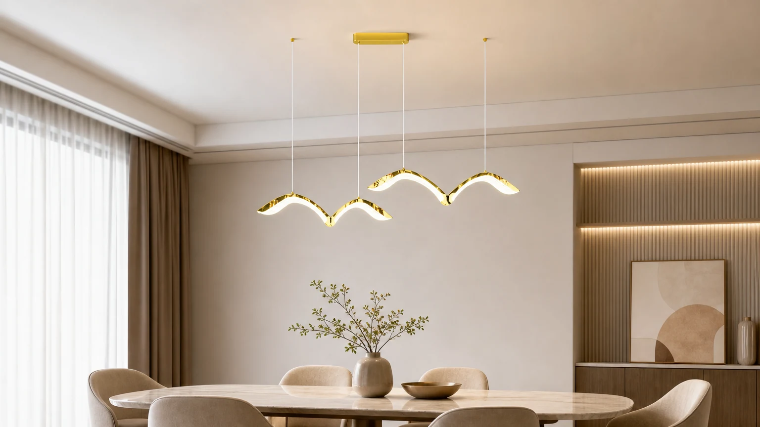 Über einem Esstisch ist ein goldener, gebogener LED-Kronleuchter in Form einer Möwe angebracht.